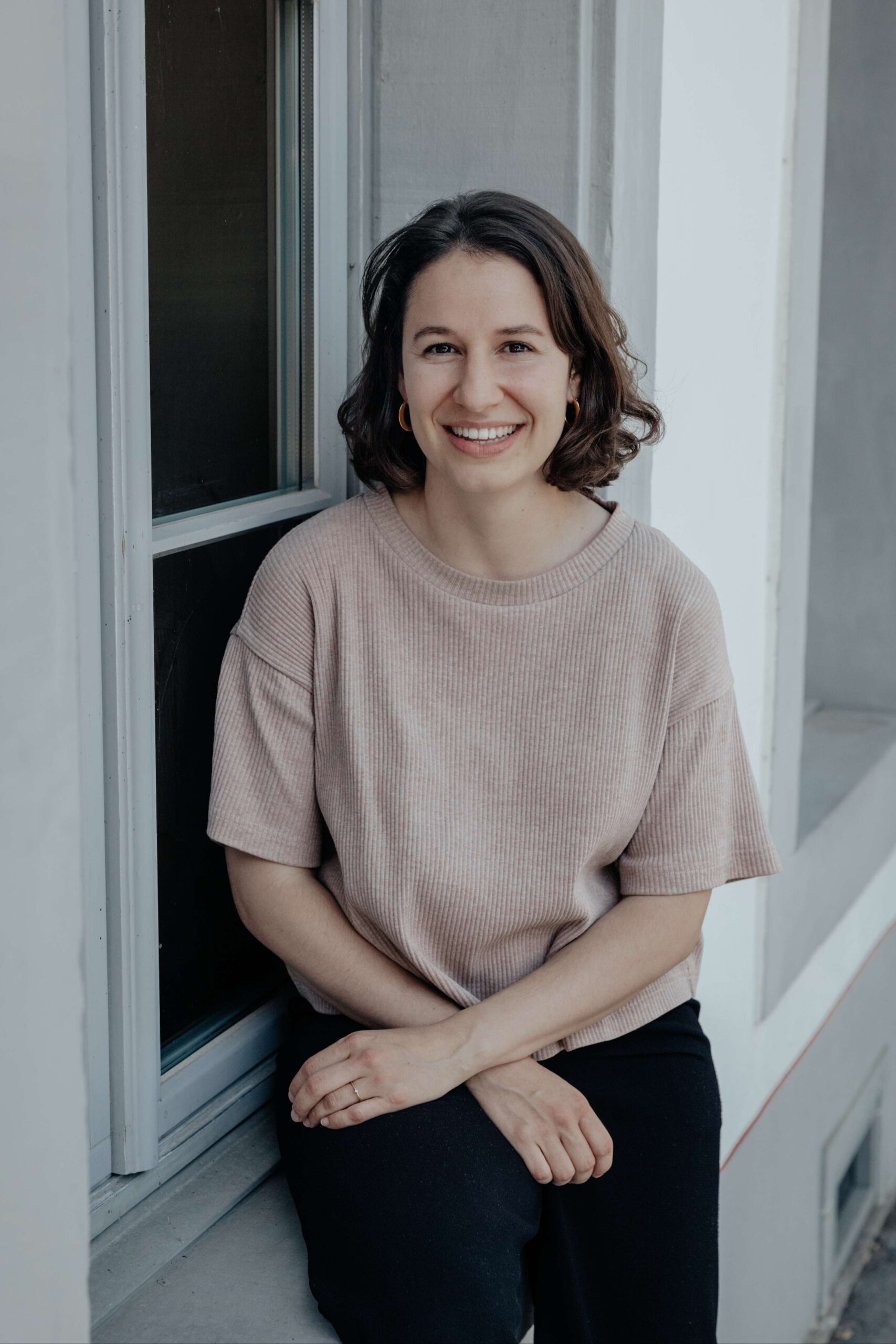 Portrait von Annina, sitzend auf einem Fensterbank.